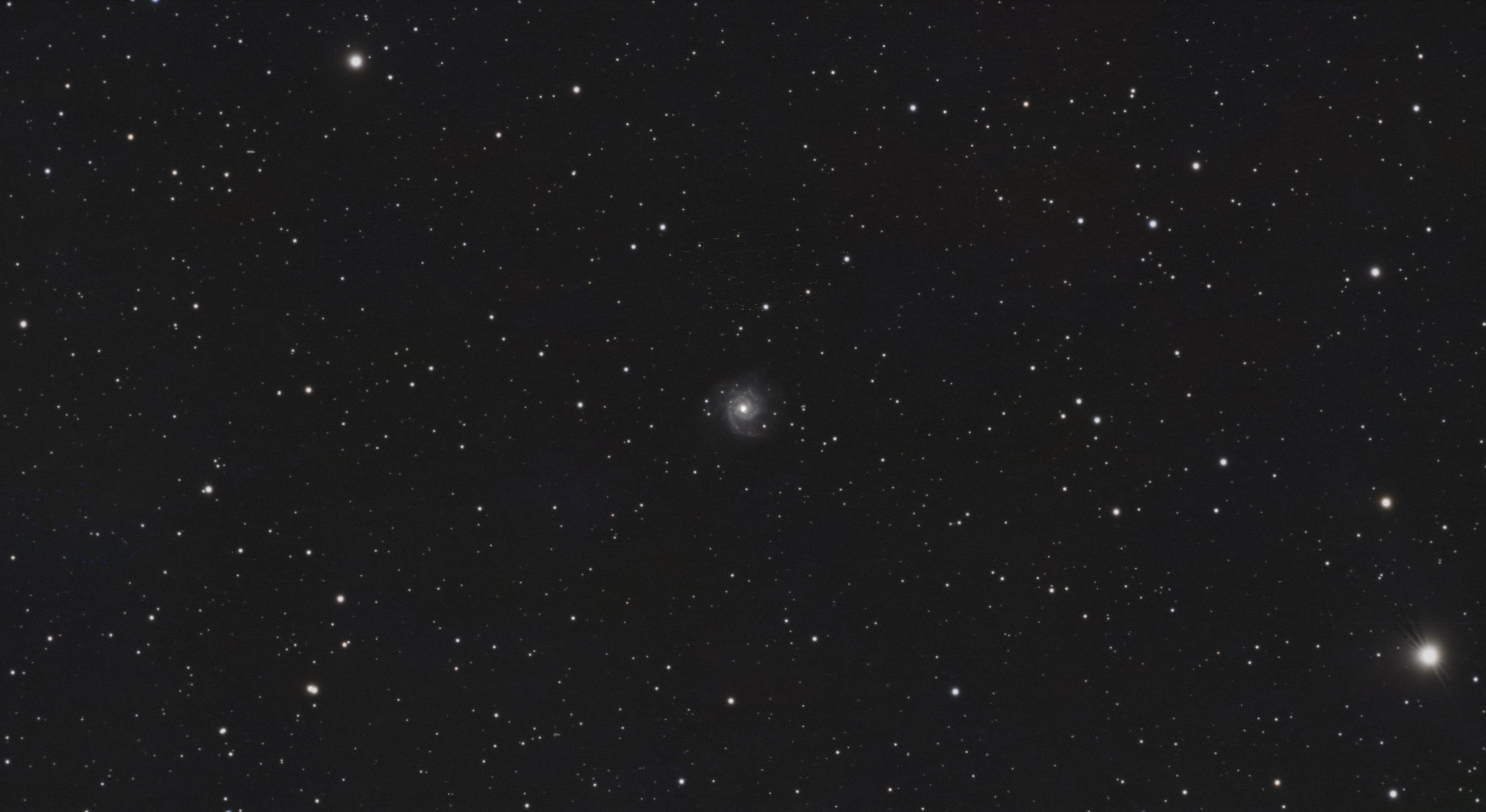 The face-on spiral galaxy M74 with a bright core and faint spiral arms in a wide star field